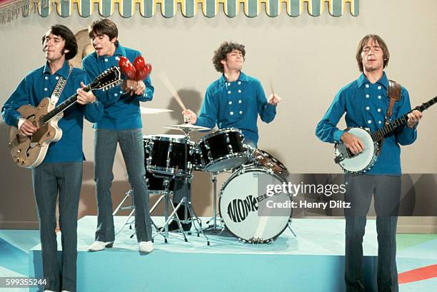The Monkees perform on their television show wearing matching blue shirts.