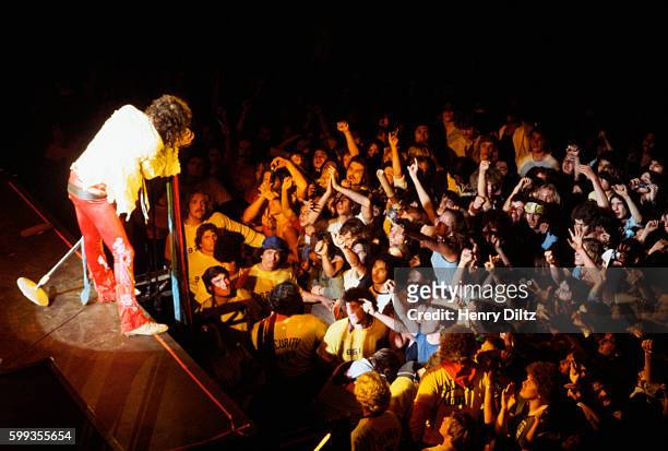 Steven Tyler sings at the edge of the stage during an Aerosmith concert.