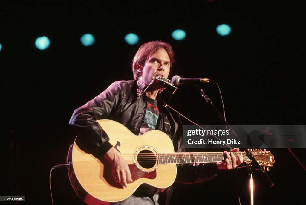 Neil Young Playing Guitar and Harmonica