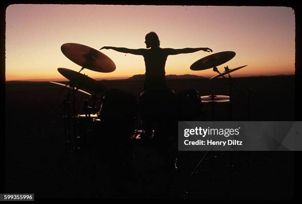 Russ Kunkel poses behind his drum set at sunset, forming a dramatic silhouette. He is filming an instruction video for beginning drummers in...