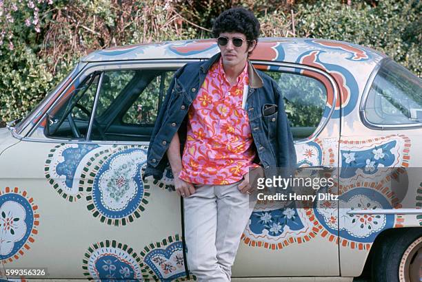 Cyrus Faryar of MFQ, or the Modern Folk Quartet, leans against his paisley painted car, a gift from the singing group the Mamas and the Papas.
