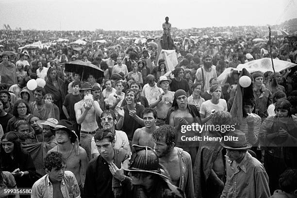 Audience members stand in the rain at the free Woodstock Music and Art Fair. The festival took place on Max Yasgur's dairy farm, which he rented to...