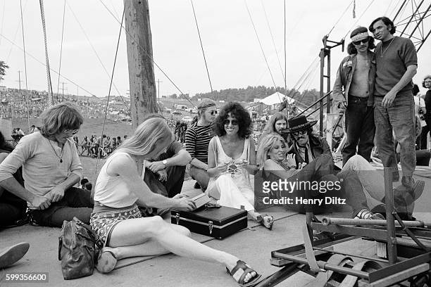 Members of Jefferson Airplane sit with promoter Bill Graham and musician Country Joe McDonald at the free Woodstock Music and Art Fair. The festival...