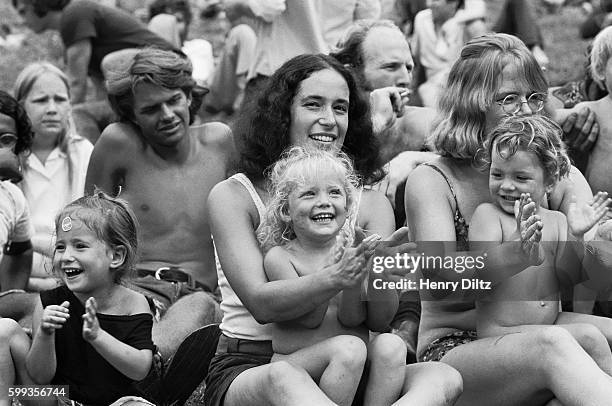 Hippies and their children relax in the grass at the free Woodstock Music and Art Fair. The festival took place on Max Yasgur's dairy farm, which he...