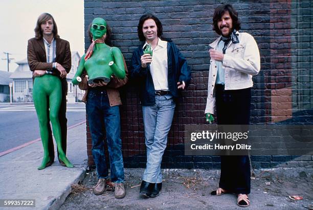 Los Angeles rock band The Doors stand alongside a brick building holding sections of a green mannequin. Left to right are: Ray Manzarek, keyboards;...