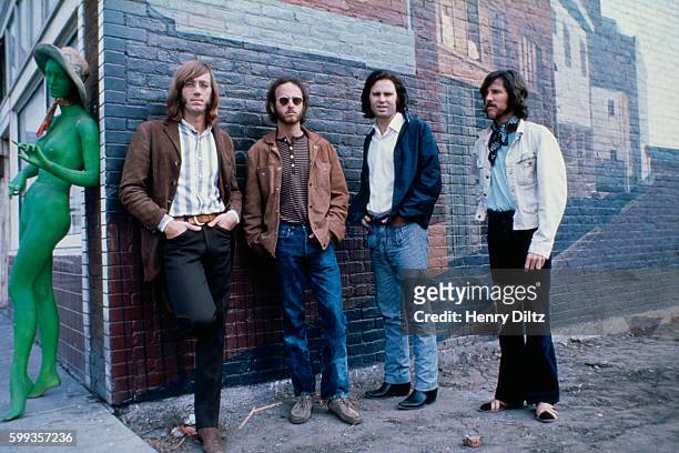 Los Angeles rock band The Doors stand alongside a brick building with an unclothed green mannequin. Left to right are: Ray Manzarek, keyboards;...