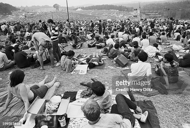 Audience members sit out of view of the stage at the free Woodstock Music and Art Fair. The festival took place on Max Yasgur's dairy farm, which he...
