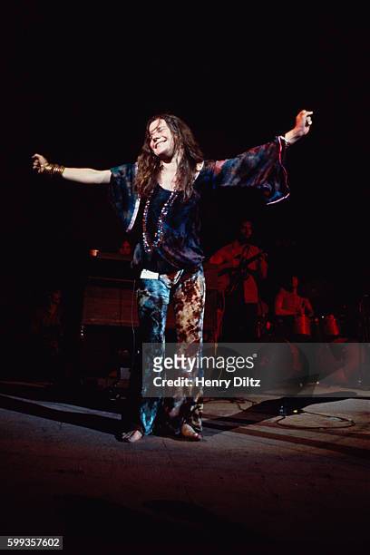 Janis Joplin stands with arms outstretched during her performance at the Woodstock Music and Art Fair. | Location: Near Bethel, New York, USA.
