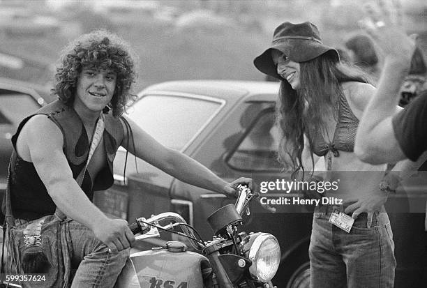 Concert producer Michael Lang sits on his motorcycle as he speaks with a hippie at the free Woodstock Music and Art Fair. The festival took place on...