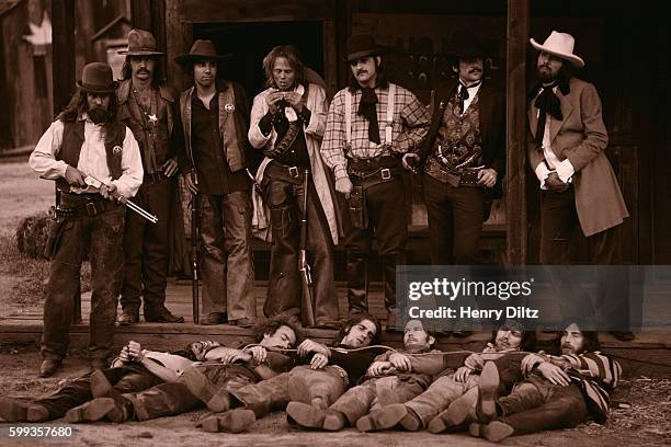 Sheriffs stand above captured and hogtied Eagles members during the Desperado album photo shoot. The dead outlaws are : Jackson Browne, Bernie...