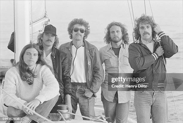 Rock band The Eagles, Timothy B. Schmit, Joe Walsh, Don Henley, Don Felder, and Glenn Frey , stand along a mast on a sailboat.