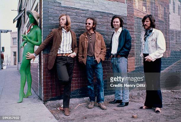 Los Angeles rock band The Doors stand alongside a brick building with an unclothed green mannequin. Left to right are: Ray Manzarek, keyboards;...