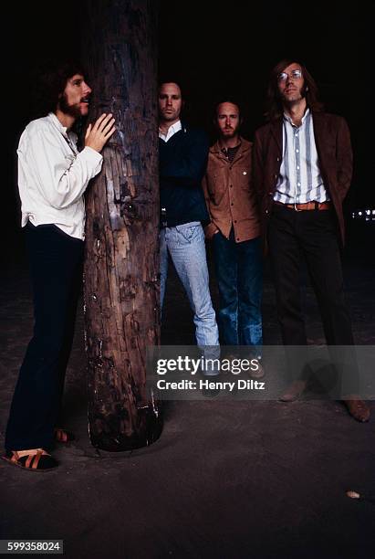 Los Angeles rock band The Doors stand alongside a piling under the Venice Pier at night. Left to right are: John Densmore, drums; Jim Morrison,...