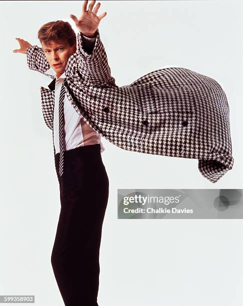 English singer and songwriter David Bowie , wearing a houndstooth check coat billowing behind him and pictured at the time of the release of his...