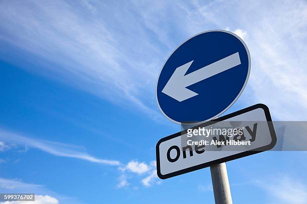 one way traffic sign against blue sky, uk - one direction stock pictures, royalty-free photos & images