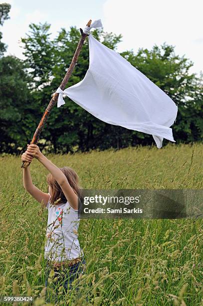 young girl raising the white flag in wheat field - white flag stock pictures, royalty-free photos & images