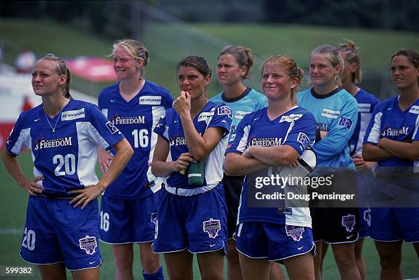 Mia Hamm, Michelle French and Krista Davey of the Washington Freedom look on from the field with other teammates during the WUSA game against the New...