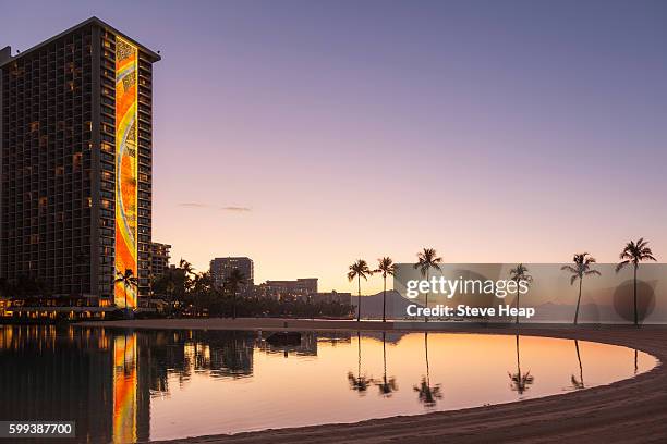 newly restored tiling mural by millard sheets on rainbow tower at hilton hawaiian village hotel at dawn with diamond head in distance in waikiki, oahu, hawaii - hilton americas hotel stock pictures, royalty-free photos & images