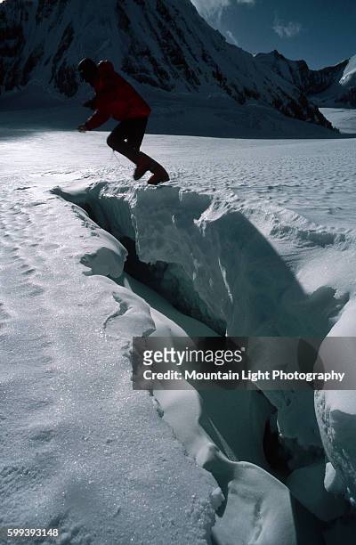 Climber jumps a crevasse on Mount Everest.