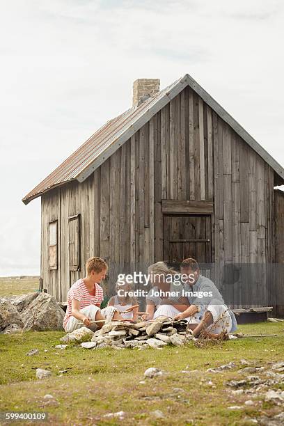 family sitting near wooden house - faro sweden bildbanksfoton och bilder