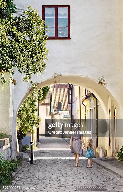 woman with daughter walking together - gamla stan stockholm stock pictures, royalty-free photos & images