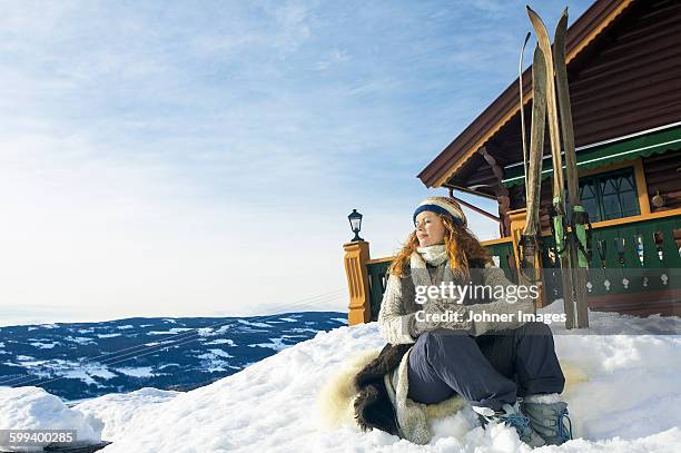 woman with mug relaxing on snow - sports glove stockfoto's en -beelden