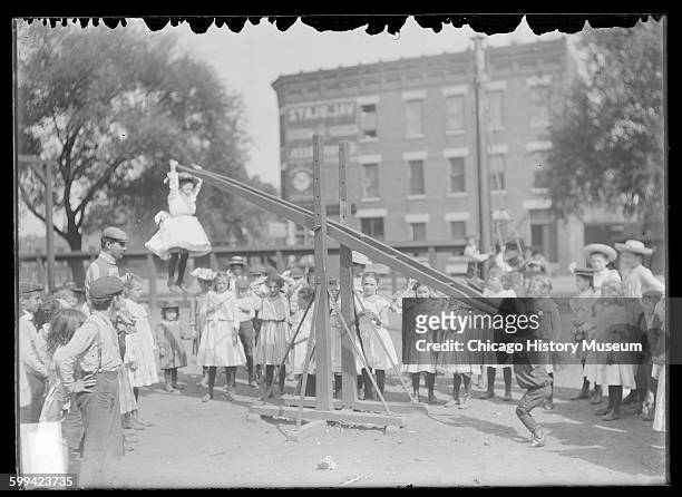 Children playing on a seesaw at the Webster School playground, located at Wentworth Avenue and 33rd Street in the Douglas neighborhood, Chicago,...