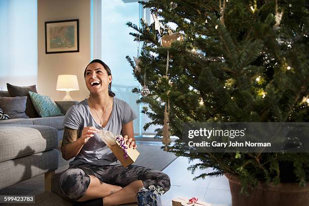 happy young woman opening a gift. - florida christmas stock-fotos und bilder