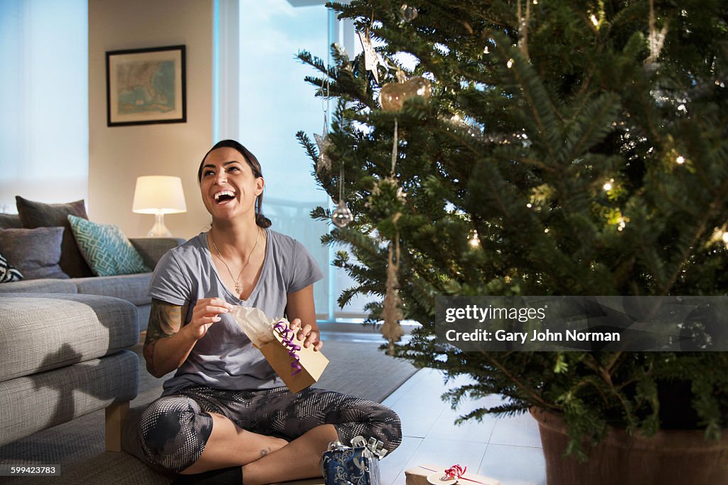 Happy young woman opening a gift.