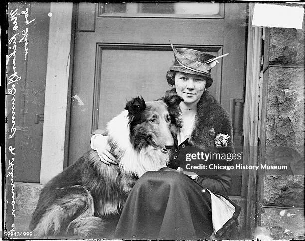 Portrait of Mrs Richard J Dunne, sitting on the steps of a building with her dog, a Hibernian , Chicago, Illinois, 1910s. They were participating in...