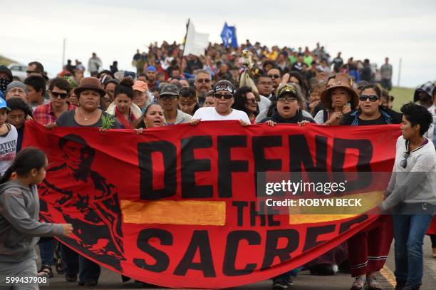 Native Americans march to a burial ground sacred site that was disturbed by bulldozers building the Dakota Access Pipeline , near the encampment...