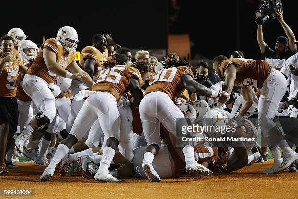 The Texas Longhorns celebrate defeating the Notre Dame Fighting Irish 50-47 in a second overtime at Darrell K. Royal-Texas Memorial Stadium on...