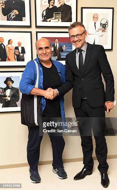 Jaeger LeCoultre Communications Director Laurent Vinay shakes hands with director Amir Naderi before he receives the 'Jaeger-LeCoultre Glory To The...
