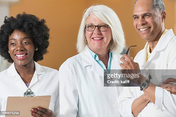 multi-racial doctors and nurses - clipboard and glasses imagens e fotografias de stock