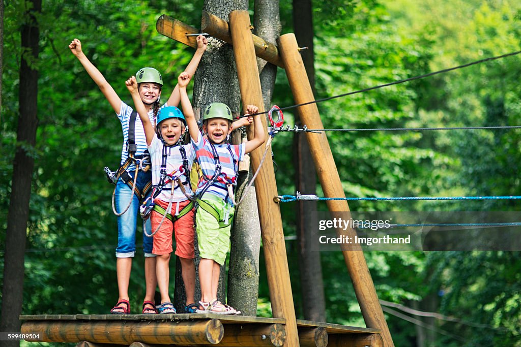 Les enfants s’amusent dans le parc d’aventure du parcours de cordes