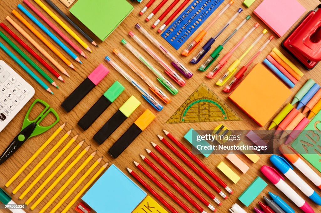 Office and school supplies arranged on wooden table - Knolling