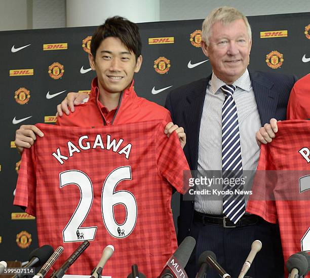Britain - Japanese midfielder Shinji Kagawa holds his jersey during a press conference at Old Trafford in Manchester, England, on July 12 as he was...