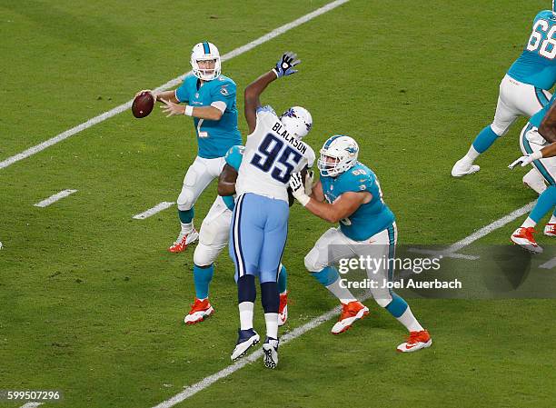 Kraig Urbik of the Miami Dolphins defends against Angelo Blackson of the Tennessee Titans as Zac Dysert throws the ball during a preseason game on...