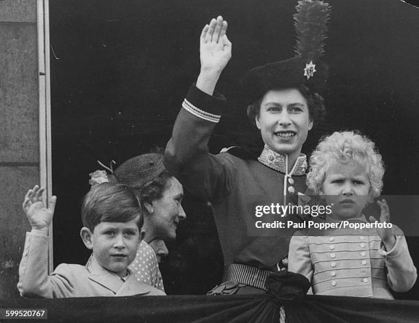 Queen Elizabeth II, wearing the uniform of Colonel in Chief of the Coldstream Guards, waves from the balcony of Buckingham Palace with Prince Charles...