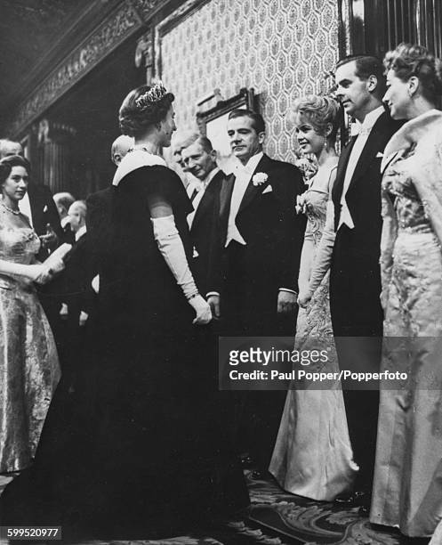 Queen Elizabeth II and Princess Margaret meet with the stars of the film 'The Battle of the River Plate' following the Royal Film Performance...