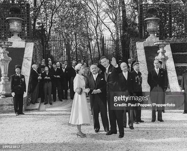 Queen Elizabeth II talks with Mr Van Der Kemp, architect of Versailles Castle, as Arts Minister Jacques Bordeneuve listens and Prince Philip, Duke of...