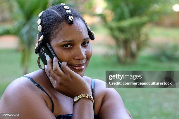 woman with traditional hairstyle with a phone - commerceandculturestock stock pictures, royalty-free photos & images