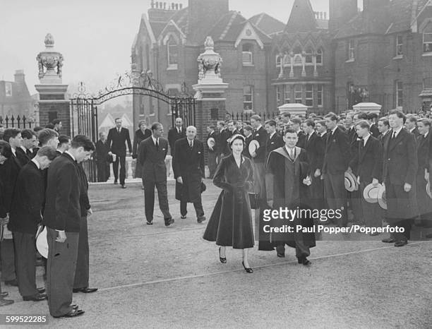 Queen Elizabeth II is accompanied by headmaster Dr Robert James, with Prince Philip, Duke of Edinburgh following behind Her Majesty, as they arrive...