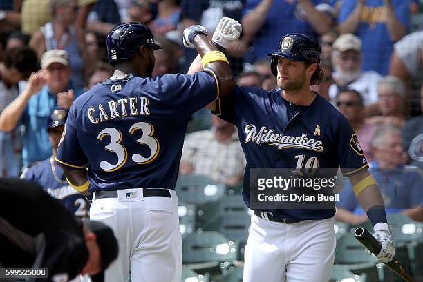 Chris Carter and Kirk Nieuwenhuis of the Milwaukee Brewers celebrate after Carter hit a home run in the second inning against the Chicago Cubs at...