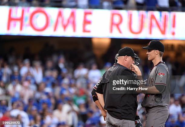 Zack Greinke of the Arizona Diamondbacks receives a visit from pitching coach Mike Butcher after a three run homerun from Corey Seager of the Los...