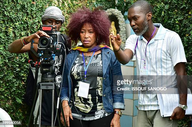 Ivorian actress, director and show creator Akissi Delta looks through a camera at a film set during the shooting of the television series 'Ma...