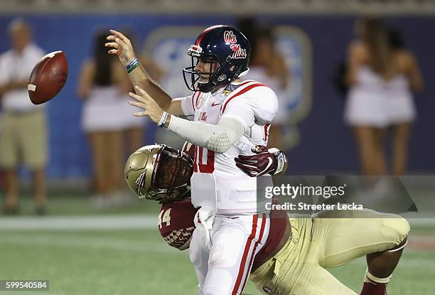 Chad Kelly of the Mississippi Rebels fumbles the ball as he is sacked by DeMarcus Walker of the Florida State Seminoles in the third quarter during...