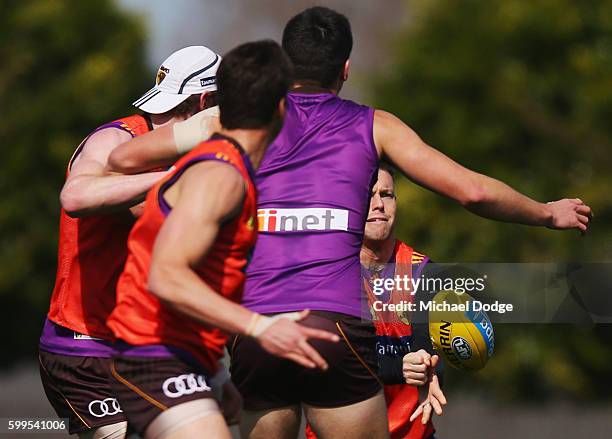Sam Mitchell of the Hawks sneaks in a handball past players during a Hawthorn Hawks AFL training session at Waverley Park on September 6, 2016 in...