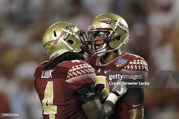 Deondre Francois celebrates with Dalvin Cook after throwing a touchdown pass to Ryan Izzo of the Florida State Seminoles in the third quarter against...