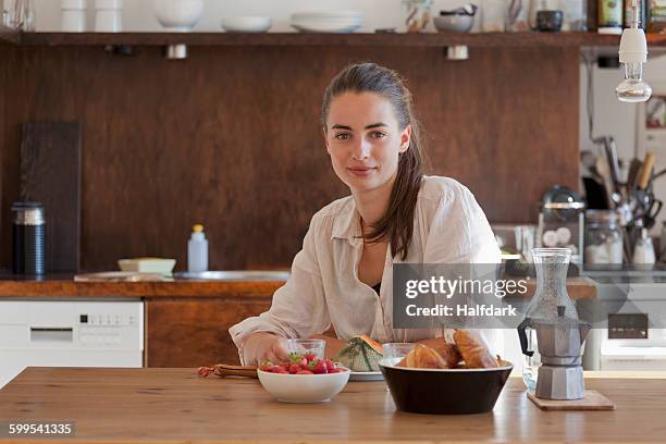 young woman sitting at dining table, portrait - fruits table top imagens e fotografias de stock